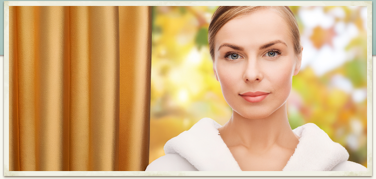 woman in autumn window at spa with gold drapes